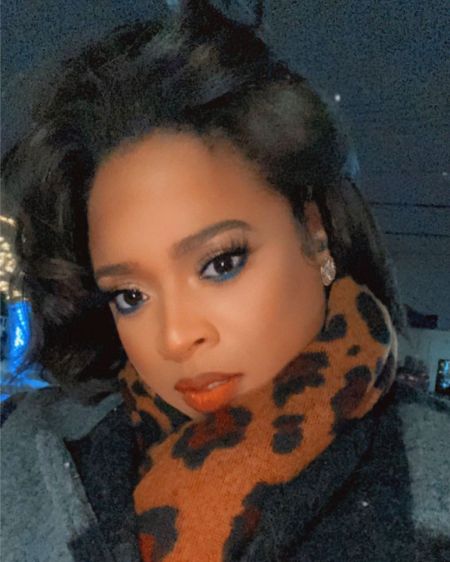 Kierra Sheard in a grey coat poses for a picture.